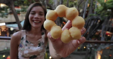 Mochi donuts, Pon de Ring Donuts, a Japanese snack. Woman showing and eating Stock Footage 132310956