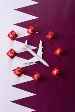 A mock up of airplane surrounded by no fly signs on a Qatari flag Stock Photos