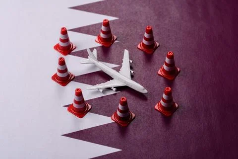 A mock up of airplane surrounded by no fly signs on a Qatari flag Stock Photos