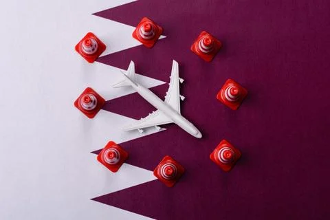 A mock up of airplane surrounded by no fly signs on a Qatari flag Stock Photos