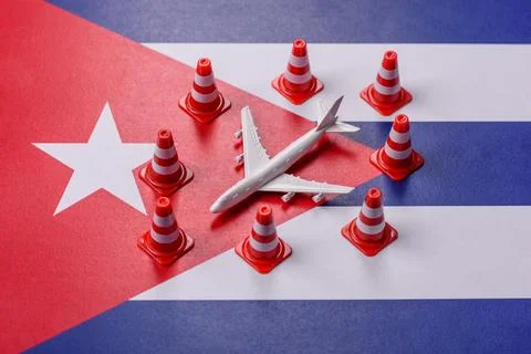 A mock up of airplane surrounded by no fly signs on a Cuba flag as a concept Stock Photos