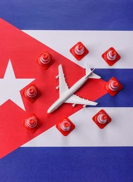 A mock up of airplane surrounded by no fly signs on a Cuba flag as a concept Stock Photos