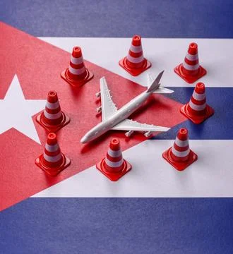 A mock up of airplane surrounded by no fly signs on a Cuba flag as a concept Stock Photos