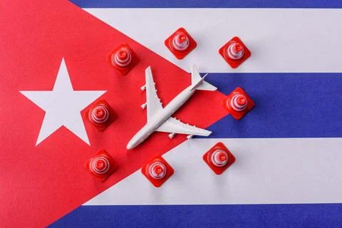 A mock up of airplane surrounded by no fly signs on a Cuba flag as a concept Stock Photos