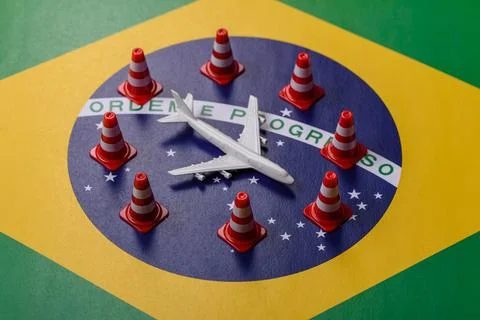 A mock up of airplane surrounded by no fly signs on a brazil flag as a concep Stock Photos