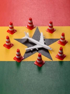 A mock up of airplane surrounded by no fly signs on a Ghana flag Stock Photos