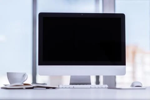 Mock up black desktop computer screen on desk at office business background Stock Photos