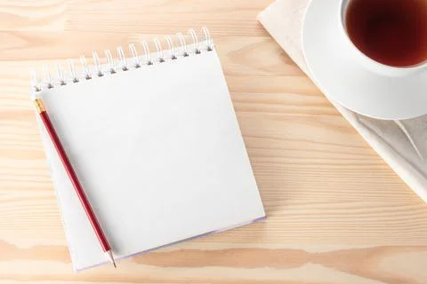 Mock up Blank notepad with pen, notebook and tea cup on wooden table. Top vie Stock Photos