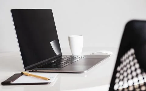 Mock up blank screen laptop and cup of coffee with other office supplies. Stock Photos