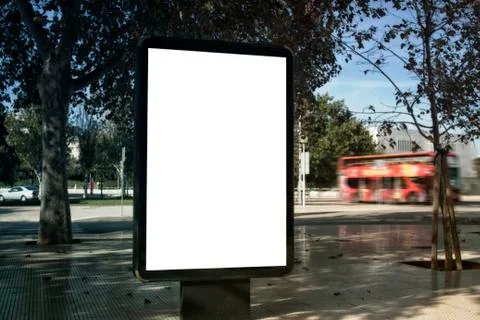 Mock up of blank white vertical light box on a street, in a city against the  Stock Photos