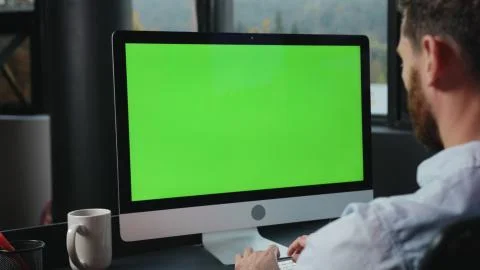 Mock-up chrome key green computer monitor on office table. Close-up manager Stock Photos