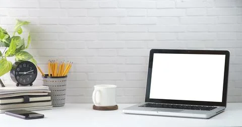 Mock up computer laptop, alarm clock, coffee cup, books and houseplant on whi Stock Photos