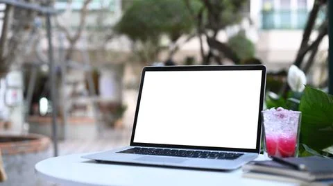 Mock up computer laptop with blank screen, notebook and fresh drink on white  Stock Photos