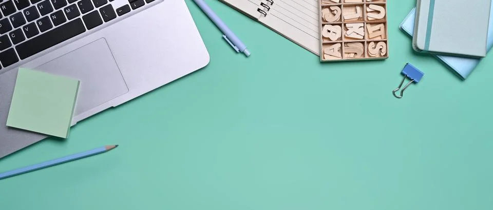 Mock up computer laptop, sticky note and notebooks on blue background. Stock Photos