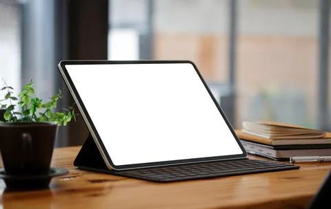 Mock up computer tablet with white display, red coffee cup and books on woode Stock Photos