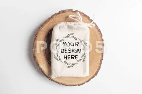 Mock up of cotton bag or pouch on wooden cut tree section on white table PSD Template