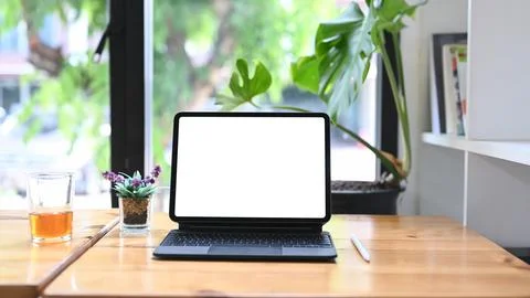 Mock up digital tablet with wireless keyboard on wooden table. Stock Photos
