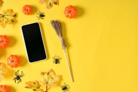 A mock-up of an empty Halloween phone with pumpkins and spiders on a yellow b Stock Photos