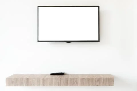 Mock up flat tv screen with remote panel on wwden shelf in living room at hom Stock Photos
