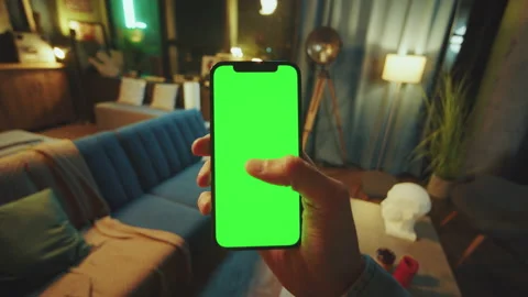 Mock up. Hands man holds a scrolling phone with a vertical green screen in a Stock Footage 238535998