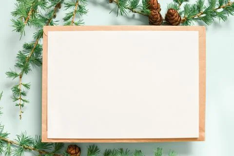 A mock-up of a kraft envelope with a blank sheet and a branch of green larch  Foto stock