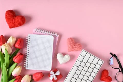 A mock-up of a kraft envelope with a blank sheet, tulips and knitted hearts. Stock Photos