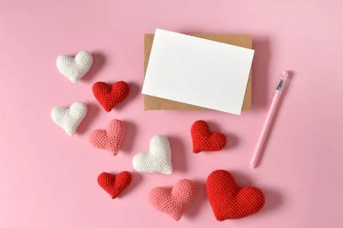 A mock-up of a kraft envelope with a blank sheet and knitted hearts. Stock Photos