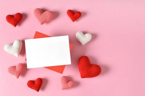 A mock-up of a kraft envelope with a blank sheet and knitted hearts. Stock Photos