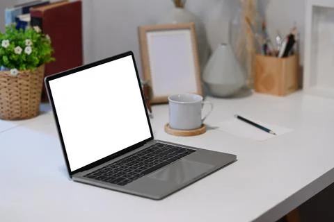 Mock up laptop computer with blank screen, office supplies and coffee cup on  Stock Photos