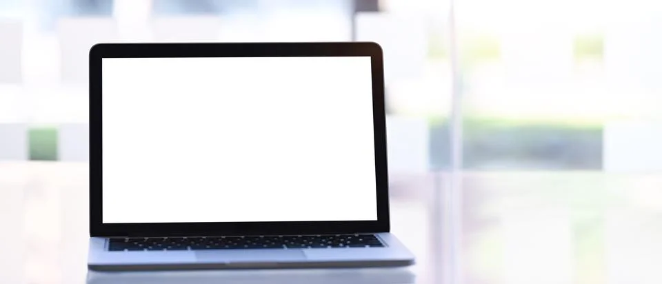 Mock up laptop computer with empty screen on white desk. White screen for adv Stock Photos