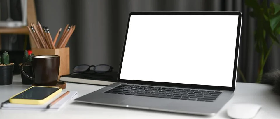 Mock up laptop computer with empty screen, smart phone and coffee cup on whit Stock Photos
