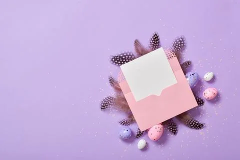 A mock-up of a pink envelope with a blank sheet of paper on a purple backgrou Stock Photos