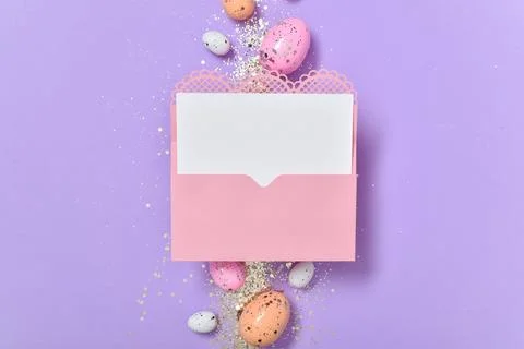 A mock-up of a pink envelope with a blank sheet of paper and Easter eggs with Stock Photos