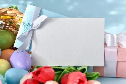 A mock-up of a postcard with tulip flowers, Easter eggs and a gift. copy spac Stock Photos