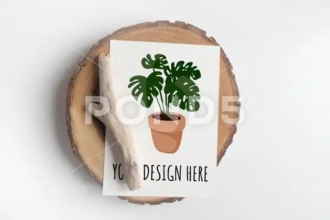 Mock up of postcard on wooden cut tree section on white table PSD-Vorlage