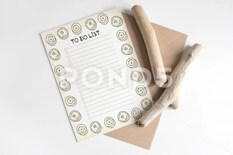 Mock up of postcard on wooden cut tree section on white table PSD Template