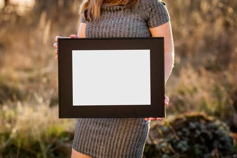 Mock up poster. Minimal template with empty picture frame mock up. Girl holdi Stock Photos