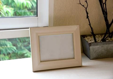 Mock up poster on table with window and green tree outside Stock Photos