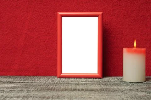 Mock up of a red frame on the background of a red wall and a wooden table nex Stock-Fotos
