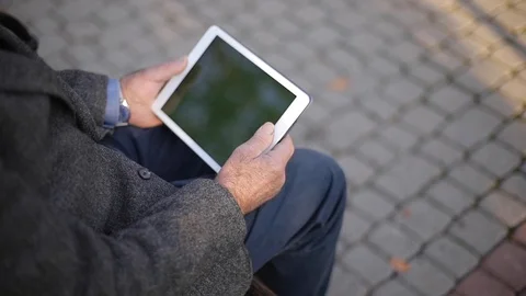 Mock up of senior man using tablet outside. Back view of elderly man sitting on Stock Footage 119308452