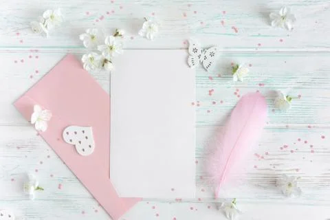 Mock up with spring cherry flowers on a light wooden background. A letter with a Foto stock