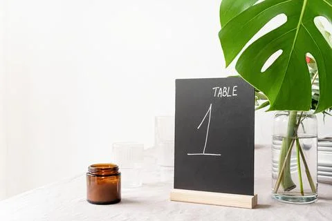 Mock up table tent with words table 1 on restaurant table with tropical bouqu Foto stock