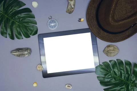 Mock up of a tablet with a white screen on the background of a hat and a comp Stock Photos