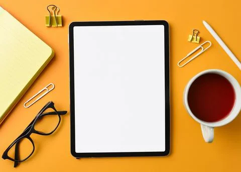 Mock-up of tablet on yellow work desk Stock Photos