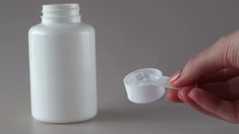 Mock-up of a white bottle of supplements and a spoonful of BCAA powder and Stock Footage 234163766
