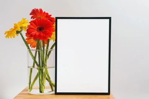 Mock up white frame and bunch of bright gerbera flowers Stock Photos