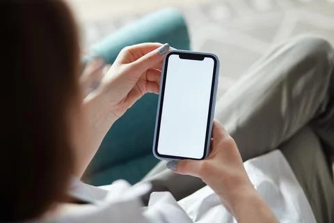 Mock up white screen blank mobile phone in woman hands holding sitting on Stock Photos