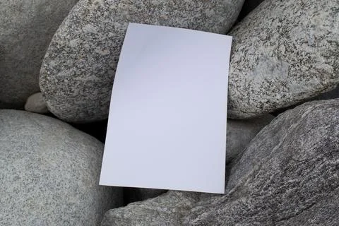 Mockup A4 sheet on large gray stones of mountain rivers. Blank for design Stock Photos