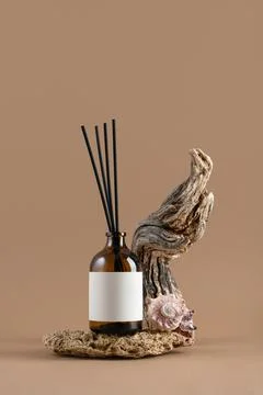 Mockup of amber glass diffuser bottle with blank label, driftwood and seashel Stock Photos