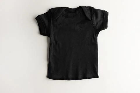 Mockup of a basic black children's T-shirt on a pink background - for a girl. Stock Photos